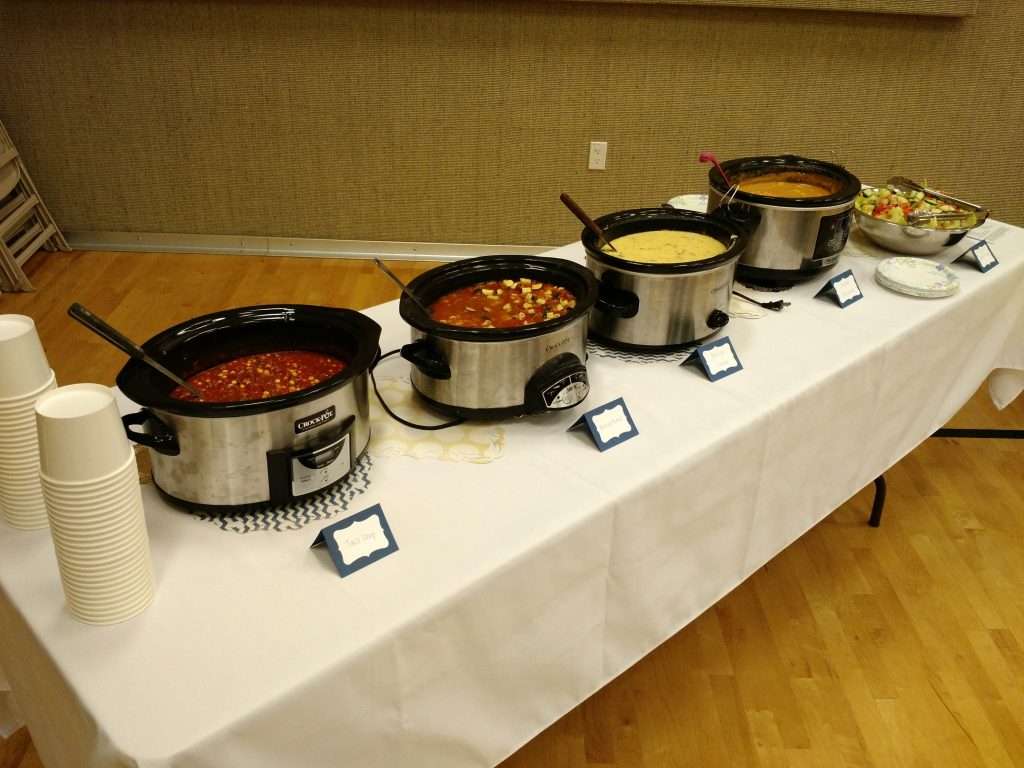 table with four crock pots of food